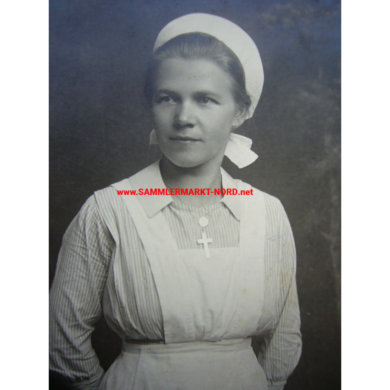 Auxiliary nurse in nurse's uniform with service cross