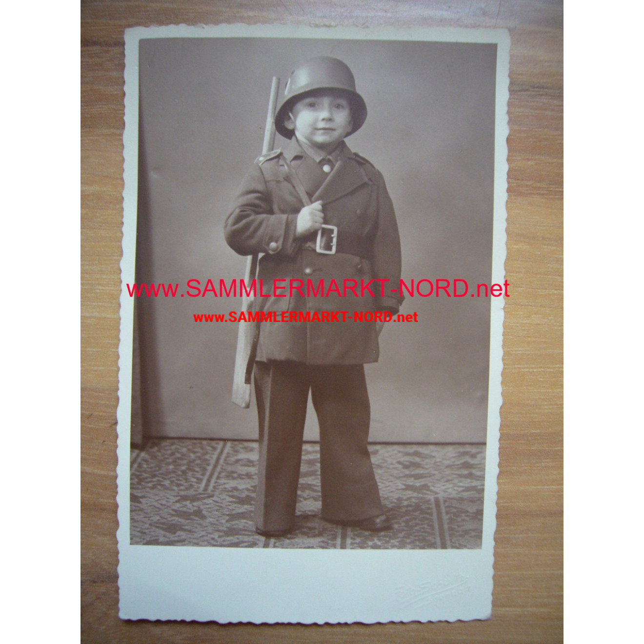 Boy in uniform of children with a steel helmet