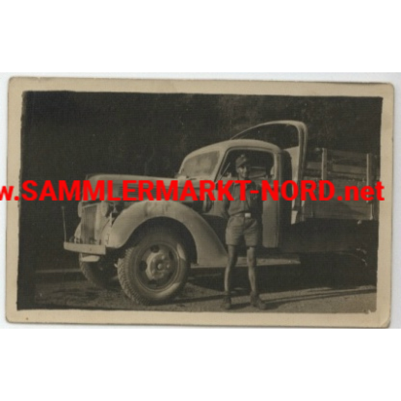 Soldier in tropical uniform in front of heavy truck