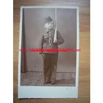 Boy in uniform for children with wooden gun