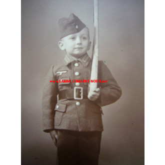 Boy in uniform for children with wooden gun