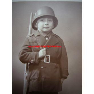 Boy in uniform of children with a steel helmet